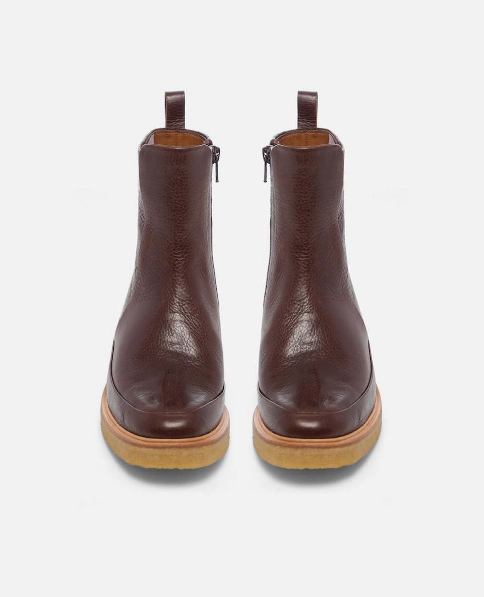 Pair of brown leather ankle boots on a white background