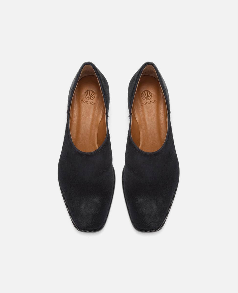 Pair of black suede shoes on a white background