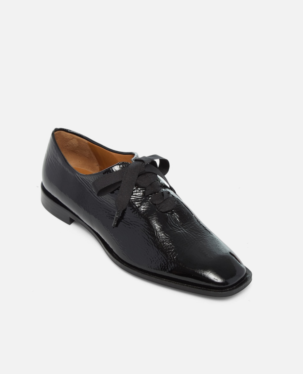 Black leather shoe with laces on a white background