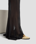 Black sheer pants with gold shoes on a light gray background 5