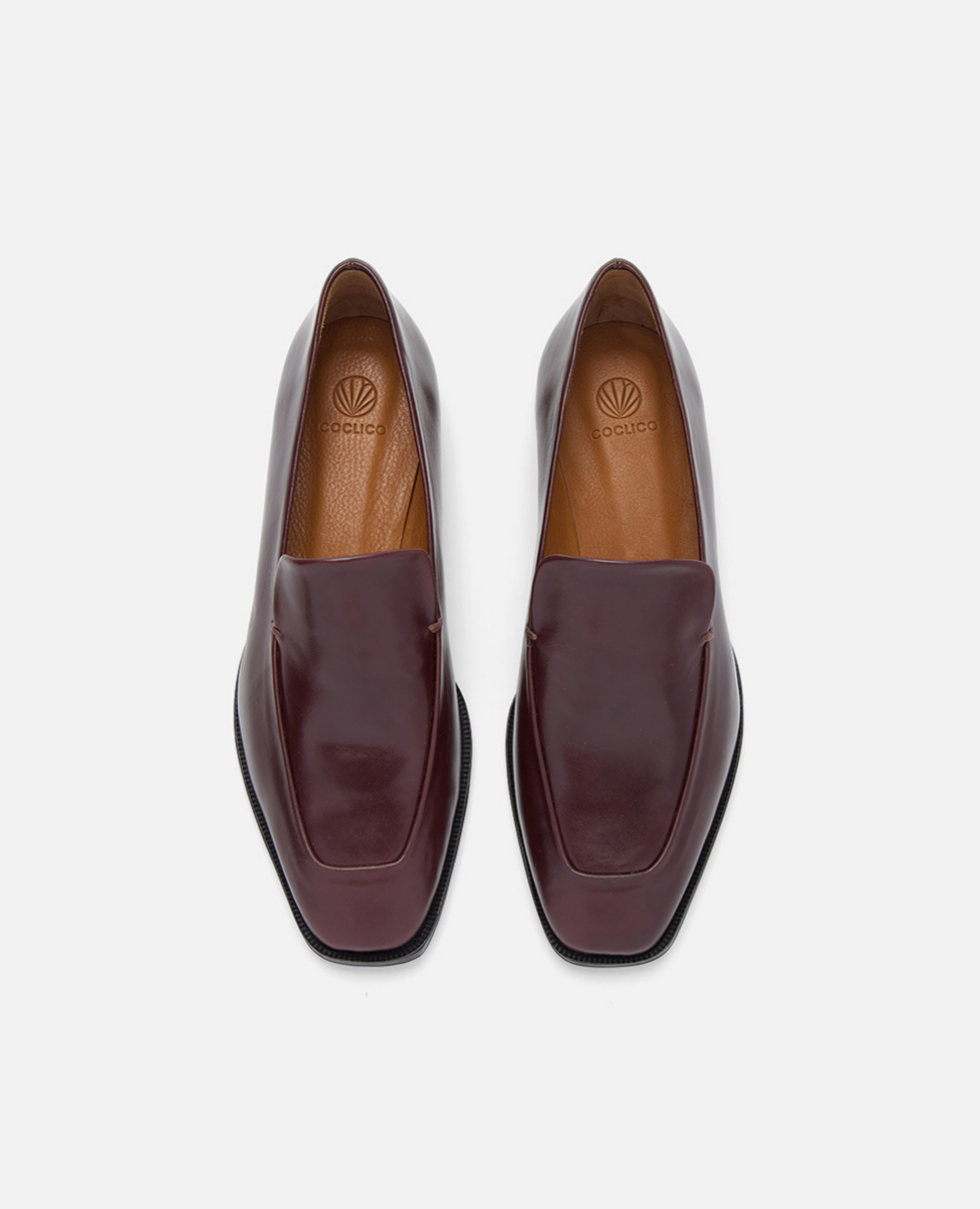 Pair of maroon loafers on a light gray background