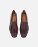 Pair of maroon loafers on a light gray background 1