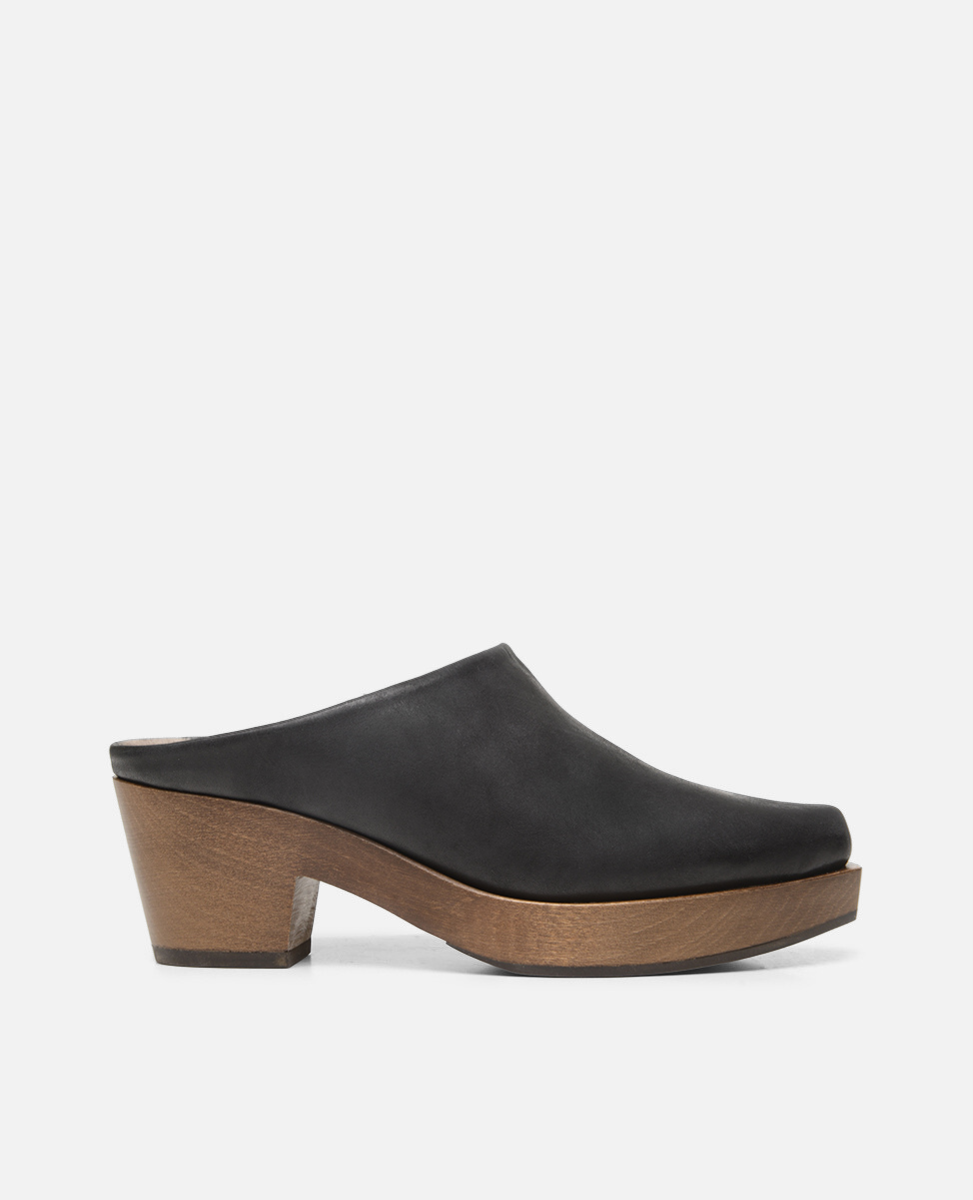 Black leather clog shoe with wooden sole on a white background