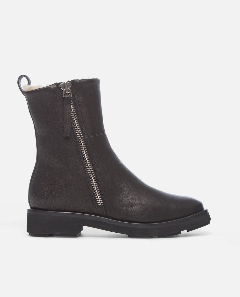 Black boot with a zipper on a light gray background