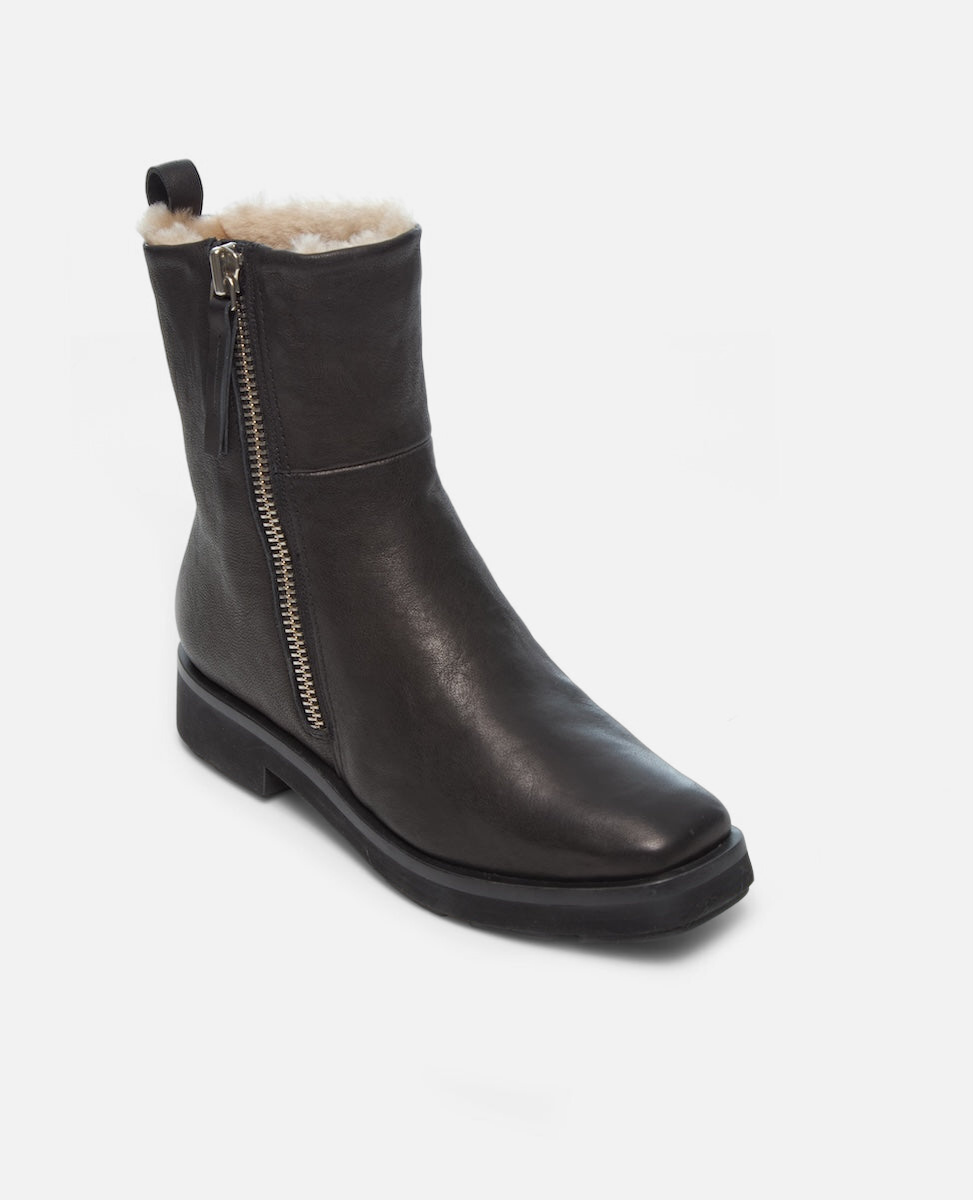 Black leather boot with fur lining and zipper on a white background
