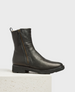 A sleek, black leather boot with a side zipper, a low heel, and a pull tab at the back, featuring shearling lining and a minimalist design. 2