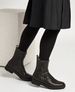 A pair of sleek, black leather ankle boots with side zippers, a slightly squared toe, and a low, sturdy heel, featuring a smooth, polished texture and a pull tab at the back. 1