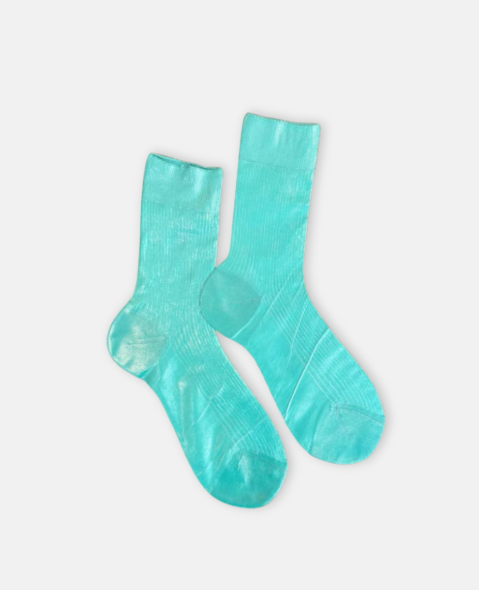 Pair of metallic foil aqua blue green silk socks by Maria La Rosa on a light gray background