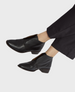 Sleek black leather ankle boots with a rounded toe, low leather stacked heel,  easy slip-on wear. 7