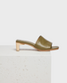 A sleek olive green leather mule with an open toe design, featuring a low wooden block heel and a smooth, minimalist finish. 1