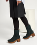 Dark green, mid-calf suede boots with a wooden block heel, side zipper, and a soft, fur-lined interior. 2