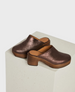 A pair of metallic brown clogs featuring a wooden platform heel and sole, and an open back design. 2