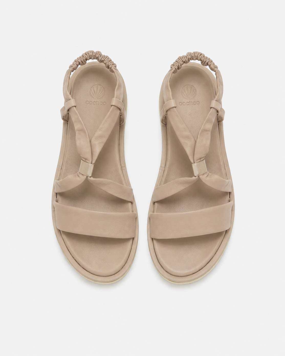 Pair of beige sandals on a white background