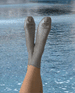 Gif of feet in the air wearing silver silk socks, silvery water moves behind the socks 4