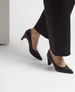 Black, pointed-toe, mid-heel shoes with a smooth leather finish, worn with black pants. 3