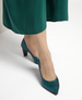 A pair of elegant, teal-metallic high-heeled shoes with a pointed toe and a smooth, glossy finish, worn with a green dress. 2