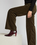 Brown corduroy pants with a wide-leg fit, paired with a black top and burgundy patent leather heeled boots. 4