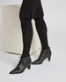 Black, pointed-toe ankle boots with a smooth leather finish, mid-height block heels, and lace-up detailing at the front. 5