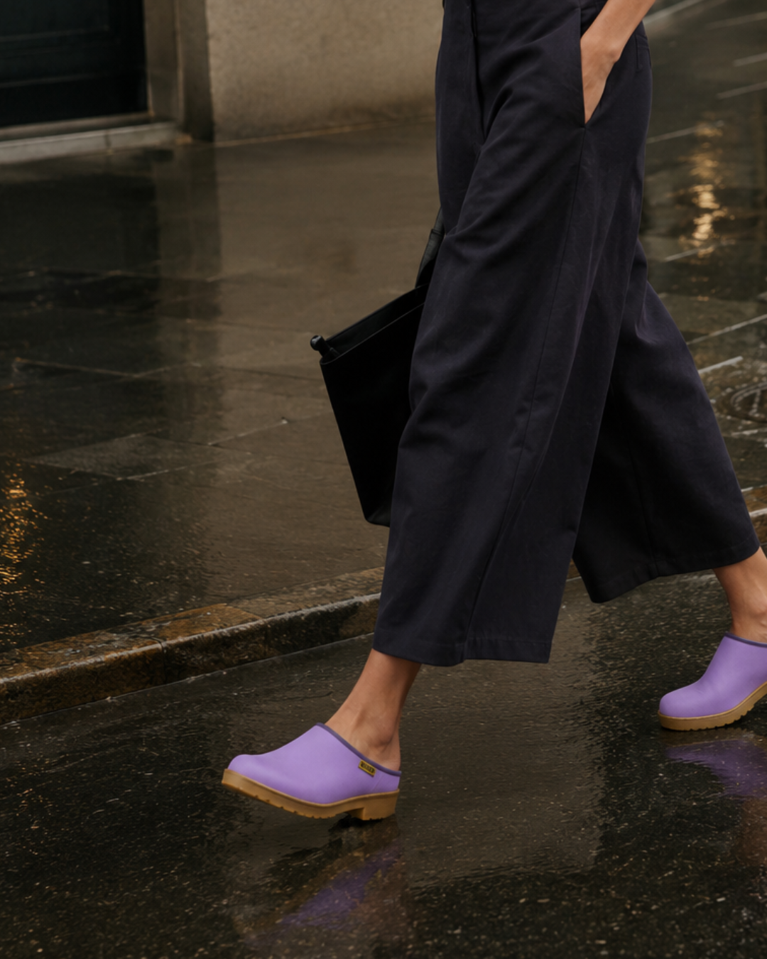 Lilac purple rain clogs worn with black wide leg pants on a rainy day in New York City