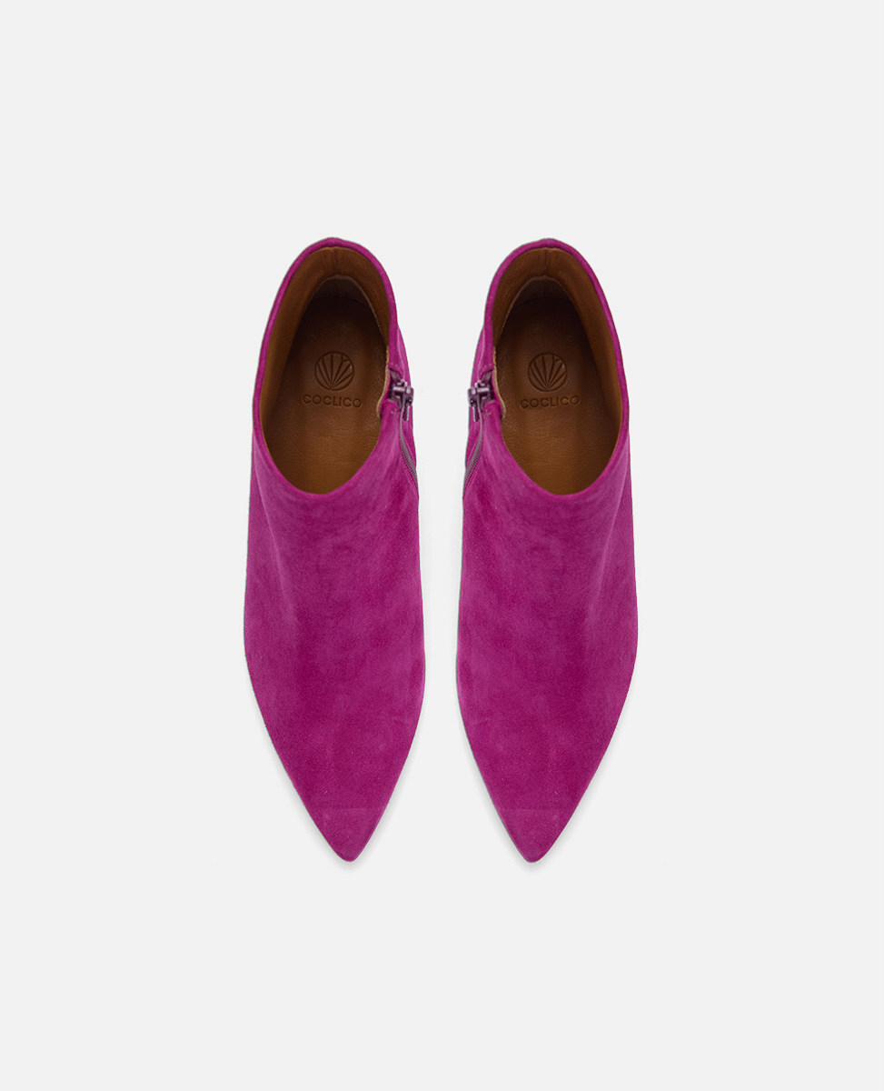 Pair of pink suede pointed-toe shoes on a white background