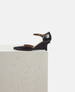 Black leather shoe on a light gray surface with a white background 4