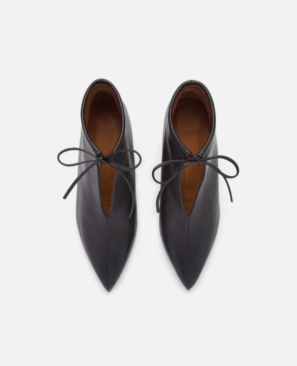 Pair of black leather shoes with brown soles on a white background