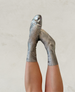 Metallic silver socks with a ribbed texture, mid-calf length, and a slightly shiny finish. 1