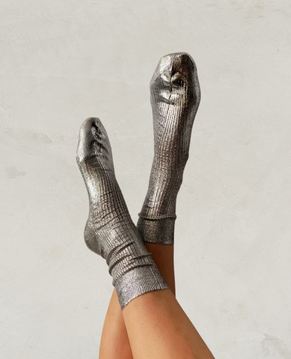 Metallic silver socks with a ribbed texture, mid-calf length, and a shiny, reflective finish.