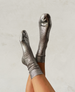 Metallic silver socks with a ribbed texture, mid-calf length, and a shiny, reflective finish. 1