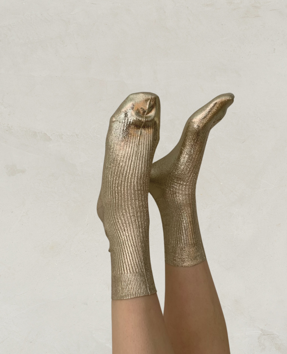 Metallic gold socks with a ribbed texture, mid-calf length, and a shiny, reflective finish.