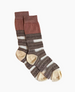 A pair of mid-calf socks featuring a ribbed cuff in a muted pink color, with alternating horizontal stripes of brown, cream, and intricate black and white patterns, and beige toe and heel sections. 3