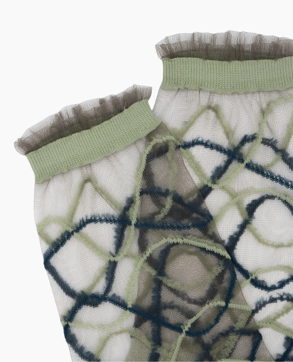 Close-up of patterned fabric with green trim on a white background