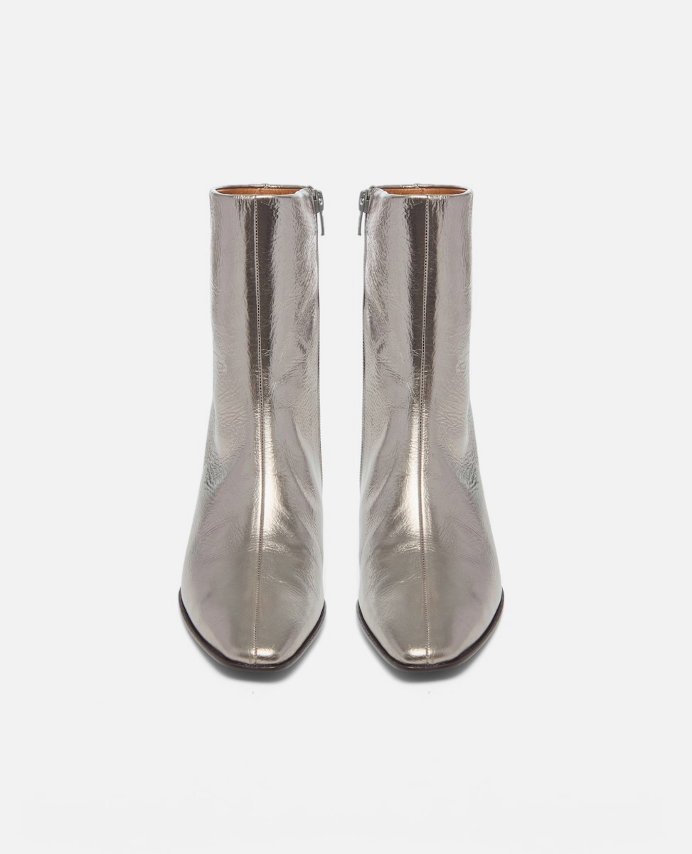 Pair of silver metallic ankle boots on a white background