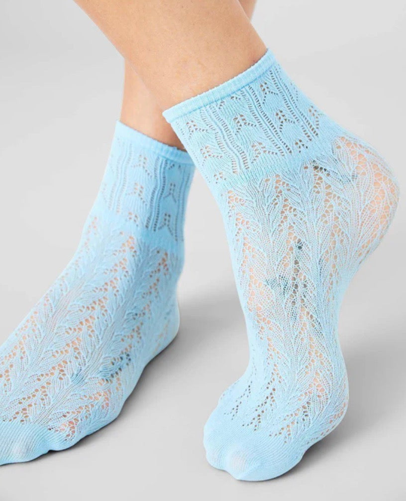 Light blue ankle socks with a delicate lace pattern featuring intricate leaf-like designs, semi-transparent texture, and a snug fit.