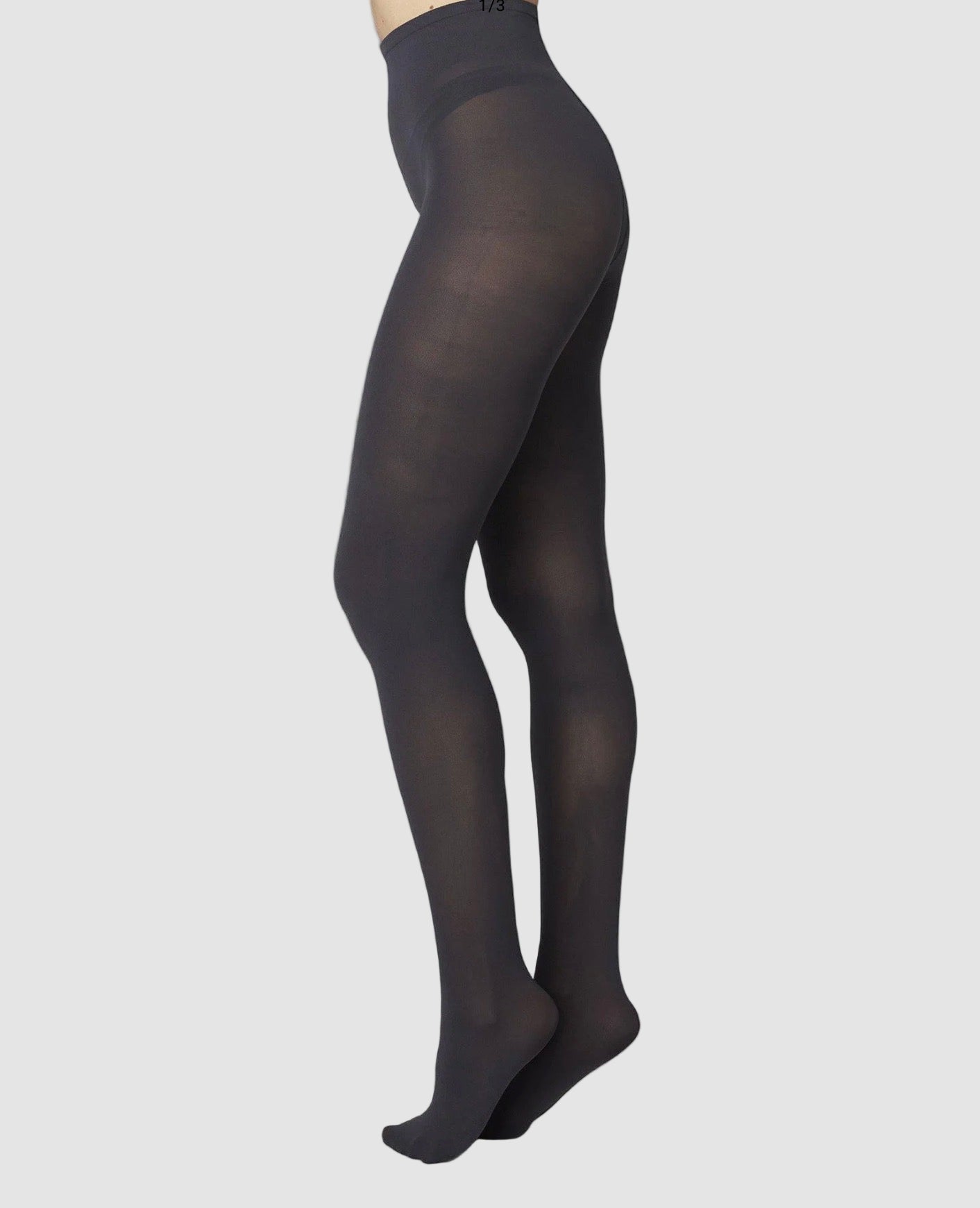 Black tights worn by a person on a white background
