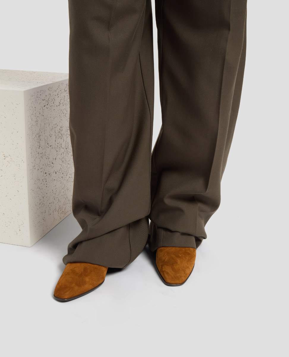 Brown pants and suede shoes on a light gray background