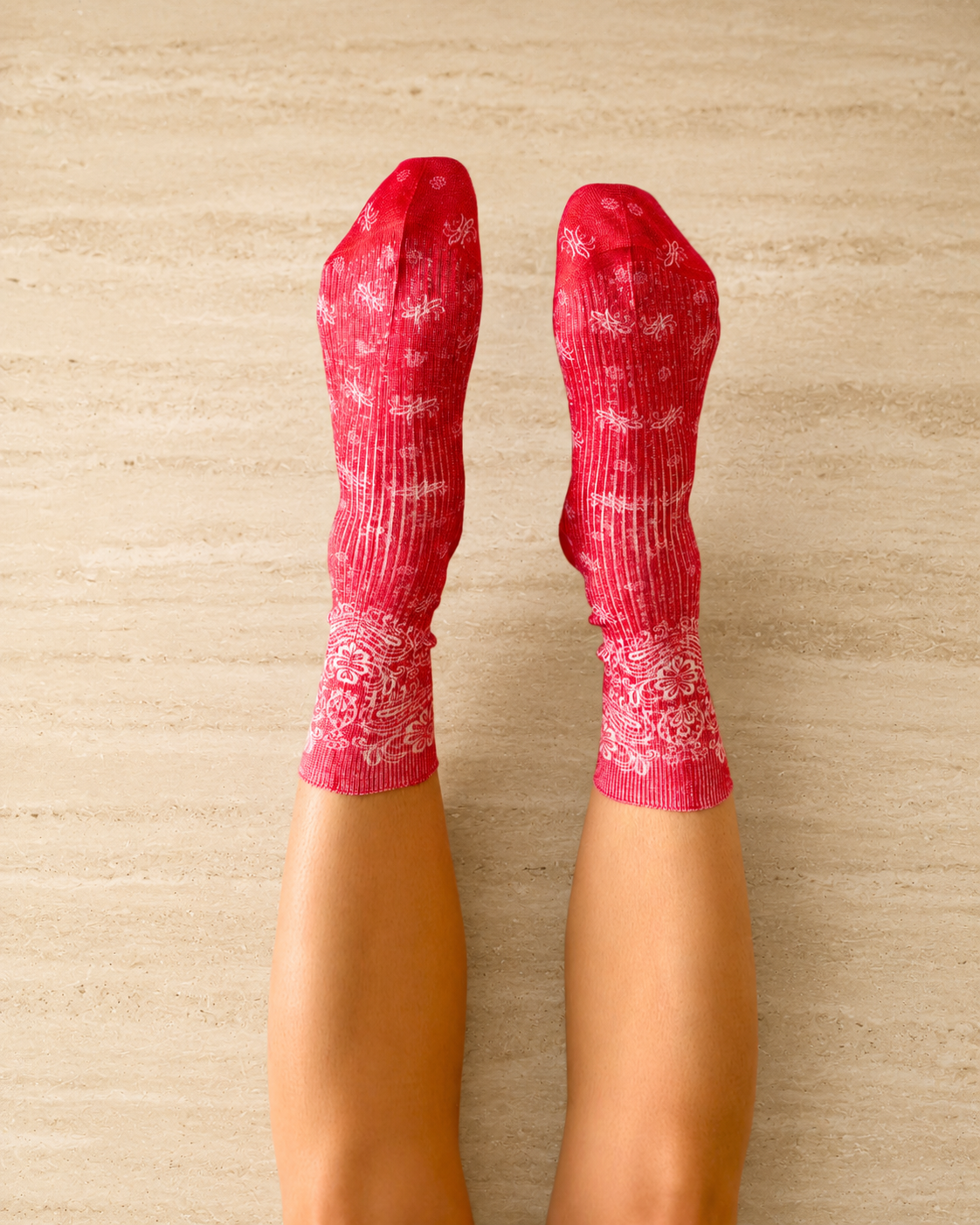 Pair of red socks with white paisley bandana pattern shown on the foot