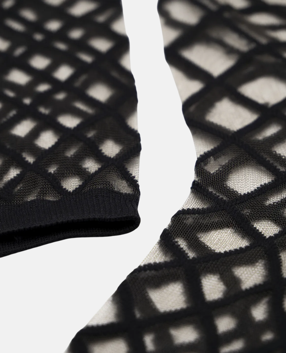 Black and white fishnet stockings with lattice pattern on a light gray background