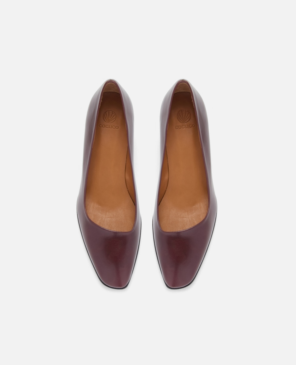 Pair of maroon high-heeled shoes on a white background