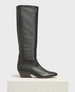 A tall, sleek black leather boot with a angular toe, a slightly slouched shaft, and a low, angled wooden heel. 2