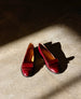 A pair of burgundy leather loafers is placed on a concrete floor, illuminated by a beam of sunlight. 7