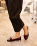 A person wearing dark pants and burgundy loafers is walking on a polished floor. 11