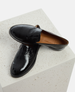 Black patent leather loafers on a light gray surface 5