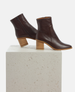 Pair of brown leather ankle boots on a white pedestal 4