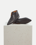 Pair of black leather shoes on a light gray pedestal 6