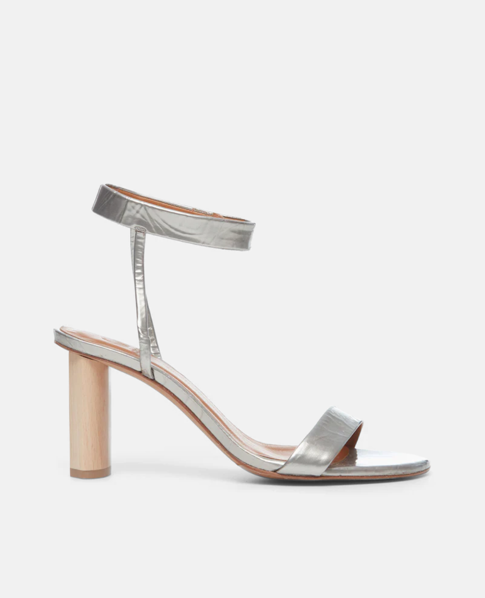 Side view of the Gina Heel in Chateau Grey Antiqued Patent, featuring a straight, narrow front strap and ankle strap that is secured with velcro for a supportive and seamless look.