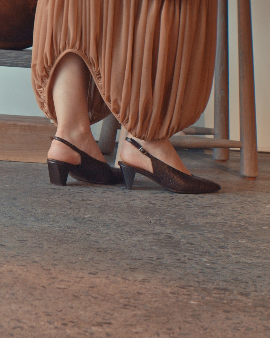 Model walking in Coclico's Sontag Slingback Pump in Espresso Snake, Gallery Setting