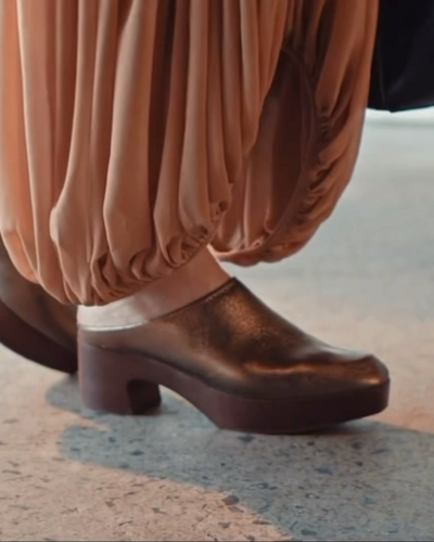 Woman wearing the Coclico Quilla Clog in Bronze Leather at a gallery