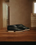 Close up, side view of the Coclico Arro Flat in Black leather, a slip-on flat with stretch leather that hugs foot, white two-part .5 inch EVA sole and a squared-off toe. 7