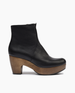 Side view of the Tecla Clog in Black; featuring clean lines, snug fit, and curved solid wood platform heel make this clog boot a timeless classic. Inside zipper closure.Italian veg-tanned leather upper with solid wood 1